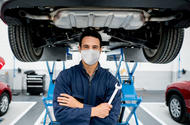 Mechanic under car with spanner